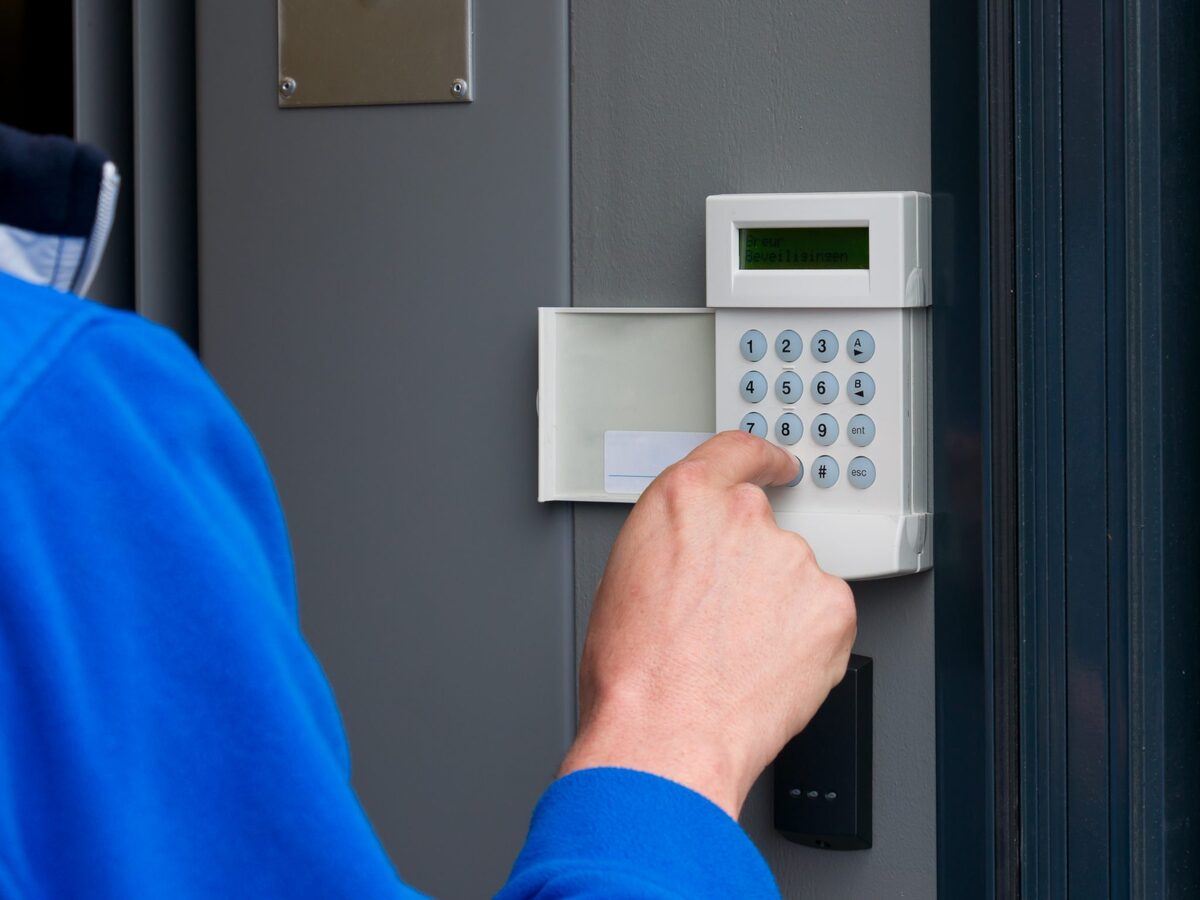 Person activating an alarm keypad — professional alarm installation by J4 Security Systems